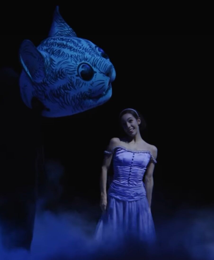 Alice (Amanda Assucena) and the Cheshire Cat (played by Guillem Cabrera Espinach, Reed Henry, Hansol Jeong, Davide Oldano, Ryo Sasaki, Jory Luther, Paul Rivard and Derek Wippel). (Photo by Cheryl Mann)